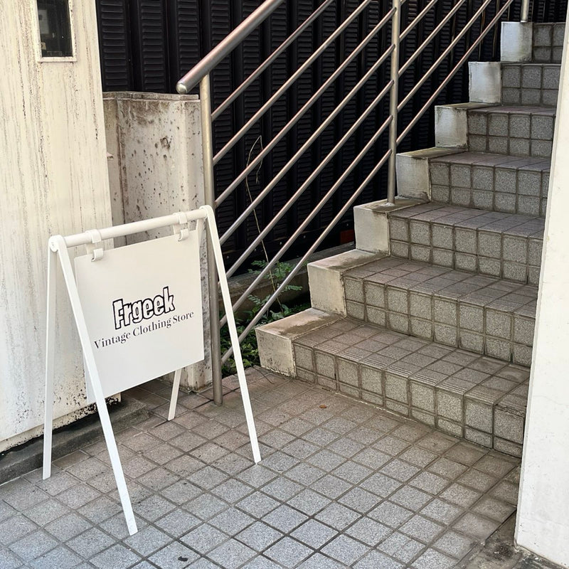 ビル1階に出した Frgeek の白い立て看板と、2階へ上がる階段